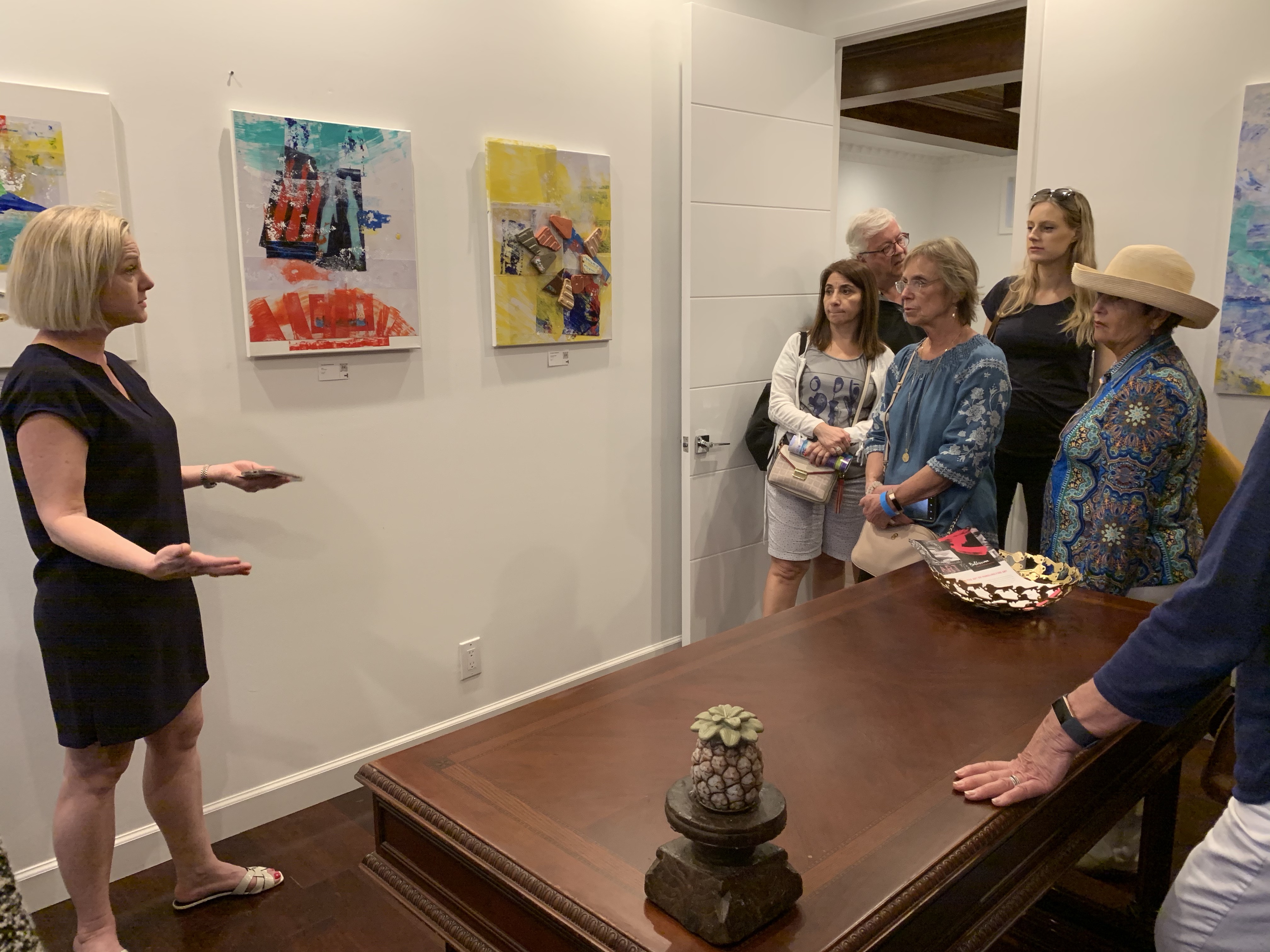 Curator, Jennifer Nayak Feldman, also known as @LasOlasLocal, speaks to a group of attendees about the art promoting the theme 'Resiliency of the Bahamian Spirit' .