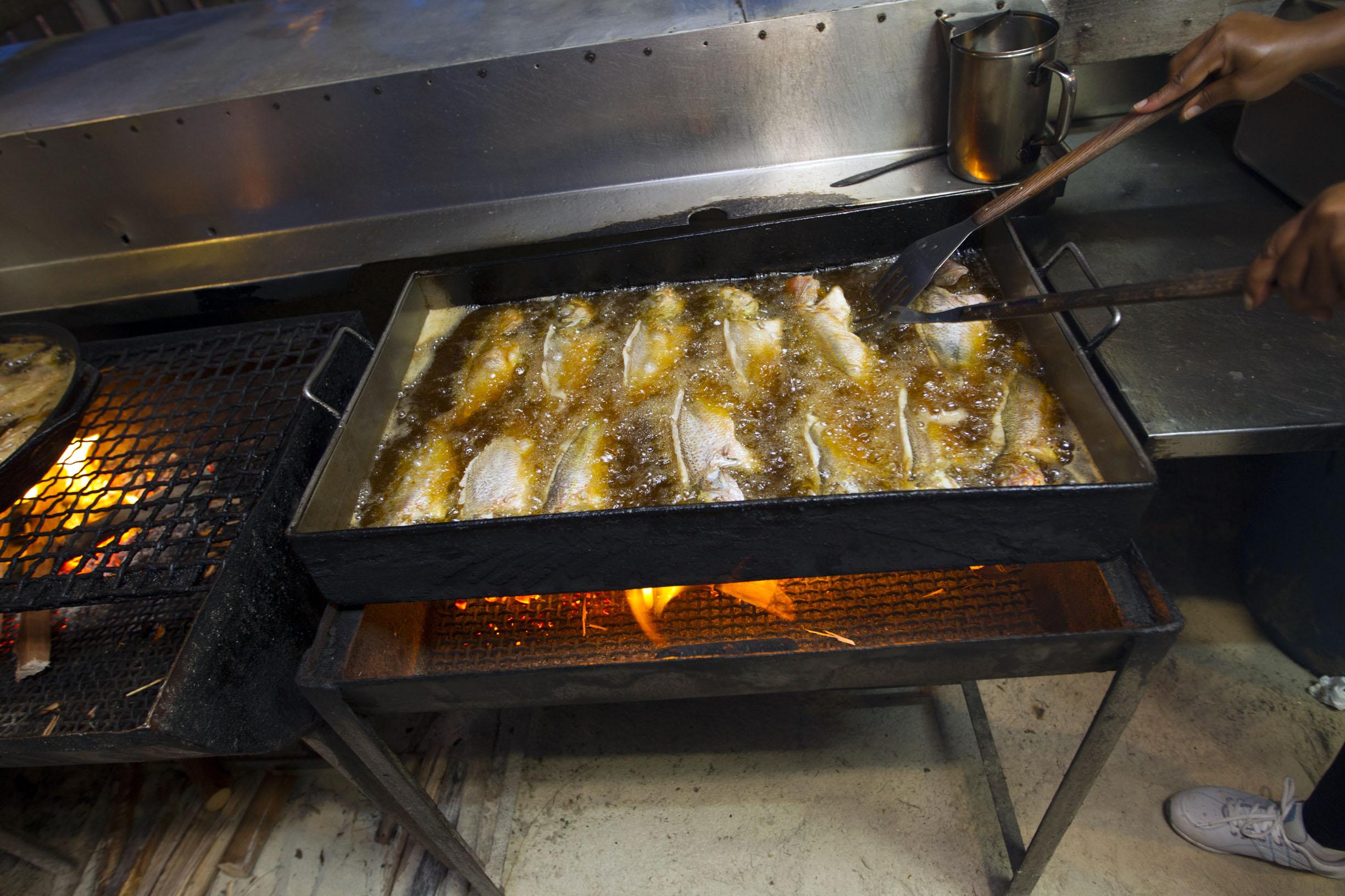 Woman frying fist at the Smith's Point Fish Fry in Grand Bahama Island, The Bahamas